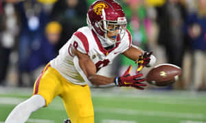 Football Player Catching Ball During Game Wallpaper