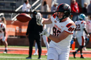 Football Player Catching Ball During Game Wallpaper