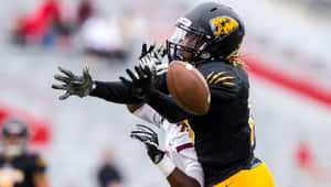 Football Player Catching Ball During Game.jpg Wallpaper