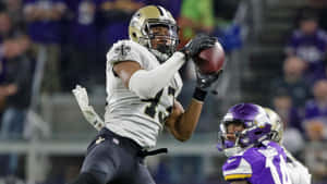 Football Player Catching Ball During Game Wallpaper