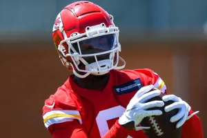 Football Player Catching Ball During Practice Wallpaper