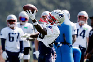 Football Player Catching Ball During Practice Wallpaper