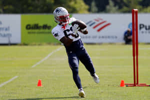 Football Player Catching Ball During Practice Wallpaper