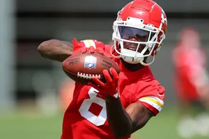 Football Player Catching Ball During Practice Wallpaper