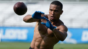 Football Player Catching Ball Practice Session Wallpaper