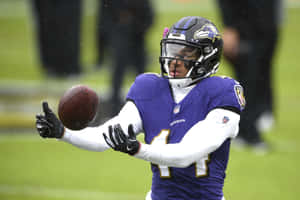 Football Player Catching Ballin Rain Wallpaper