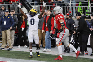 Football_ Player_ Celebrating_ Victory_ With_ Raised_ Arms Wallpaper