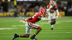 Football Player Diving Catch Attempt Wallpaper