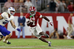 Football Player Evading Tackle During Game Wallpaper