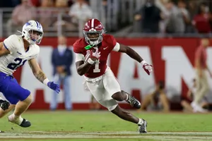 Football Player Evading Tackle During Game Wallpaper