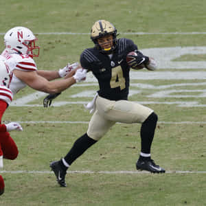 Football Player Evading Tackle Wallpaper