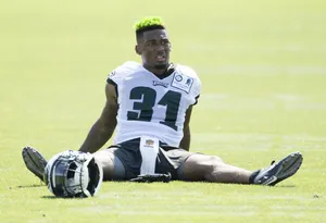 Football Player Green Hair Restingon Field Wallpaper