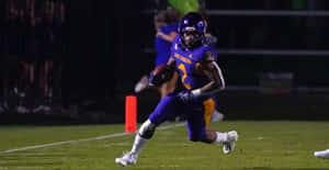 Football Player In Action During Night Game.jpg Wallpaper