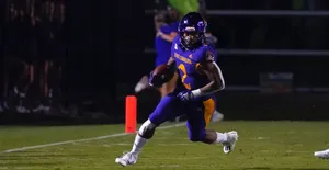 Football Player In Action During Night Game.jpg Wallpaper