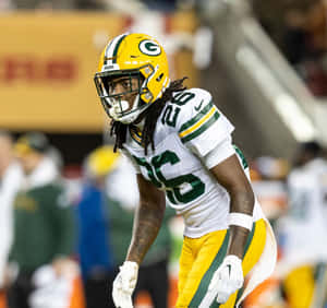 Football Player In Action Greenand Yellow Uniform Wallpaper