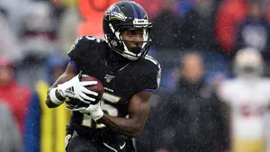 Football Player In Rain Game Action Wallpaper