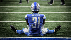 Football Player Joseph31 Sittingon Field Wallpaper