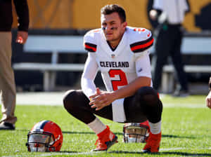 Football Player Kneeling Beside Helmet Wallpaper