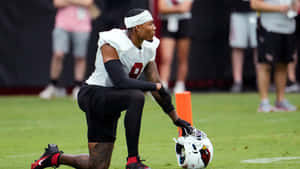 Football Player Kneeling During Practice Wallpaper