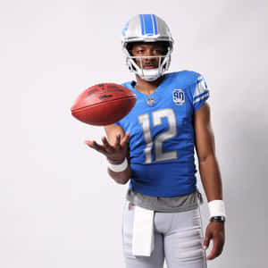 Football Player Number12 Tossing Ball Wallpaper