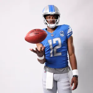 Football Player Number12 Tossing Ball Wallpaper