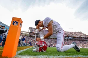 Football Player Prayingon Field Wallpaper