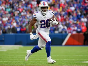 Football Player Running With Ball During Game Wallpaper