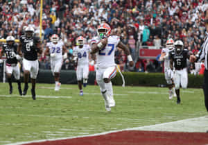 Football Player Running With Ball During Game Wallpaper