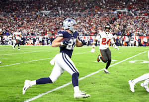 Football Player Running With Ball During Game Wallpaper