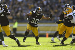 Football Player Running With Ball During Game Wallpaper