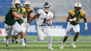 Football Player Running With Ball During Game Wallpaper