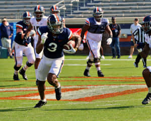 Football Player Running With Ball During Game Wallpaper