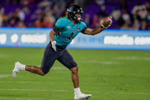 Football Player Running With Ball During Game Wallpaper