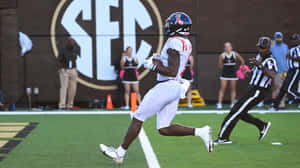 Football Player Runningon Field Wallpaper