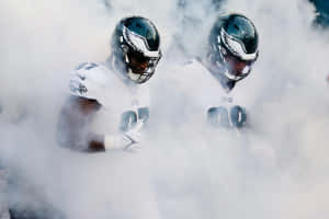 Football Players Emerging From Smoke Wallpaper