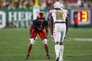 Football Players Faceoff During Game Wallpaper