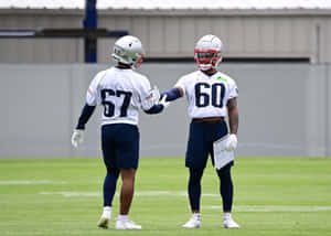 Football Players Fist Bump During Training Wallpaper