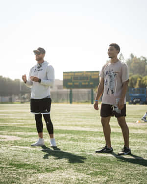 Football Players On Field During Sunny Day Wallpaper
