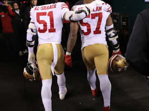 Football Players Walking Off Field Wallpaper