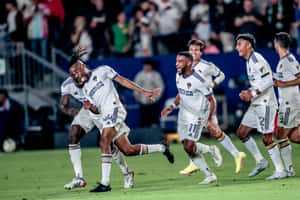 Footballer Samuel Grandsir Celebrates With La Galaxy Teammates Full Shot Wallpaper