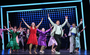 Footloose Musical Cast Dancing On Stage Wallpaper