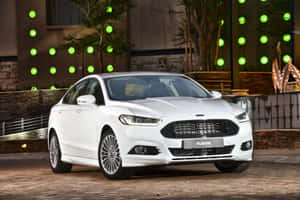 Ford Fusion Cruising On A Scenic Route Amidst Pristine Nature Wallpaper