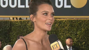 Frankie Shaw Striking A Pose On A Blue Background Wallpaper