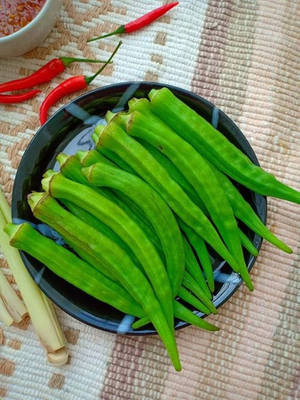 Fresh Green Okra Vegetables On A Black Plate Wallpaper