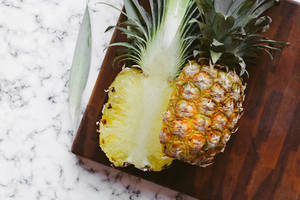 Fresh Pineapple Sliced On Chopping Board Wallpaper