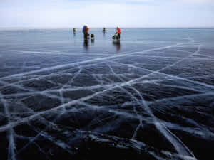 Frozen Adventure: Ice Fishing On A Serene Lake Wallpaper