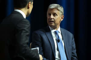 Gary Johnson Posed Against Dark Blue Curtains Wallpaper