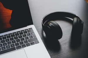 Get Ready To Boost Your Music Listening With Headphones And Laptop Wallpaper