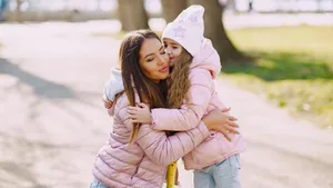 Girl Kissing Mom Left Cheek Wallpaper