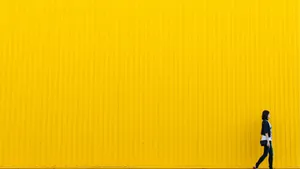 Girl Walking Through Neon Yellow Wall Wallpaper